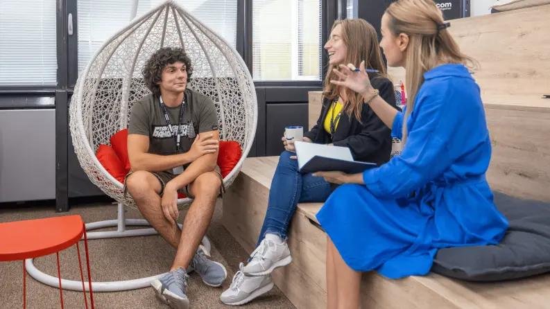 Colleagues having a casual discussion in an office lounge