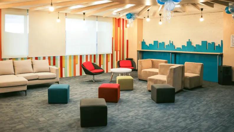 Modern jaipur office hallway with an employee recognition wall displaying team members' photos and the quote 'Our people, our pride