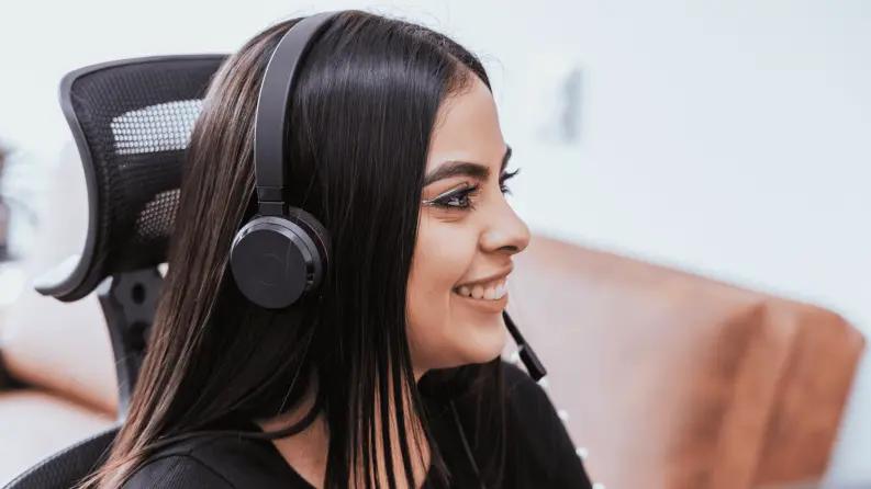 Smiling woman wearing a headset while working remotely